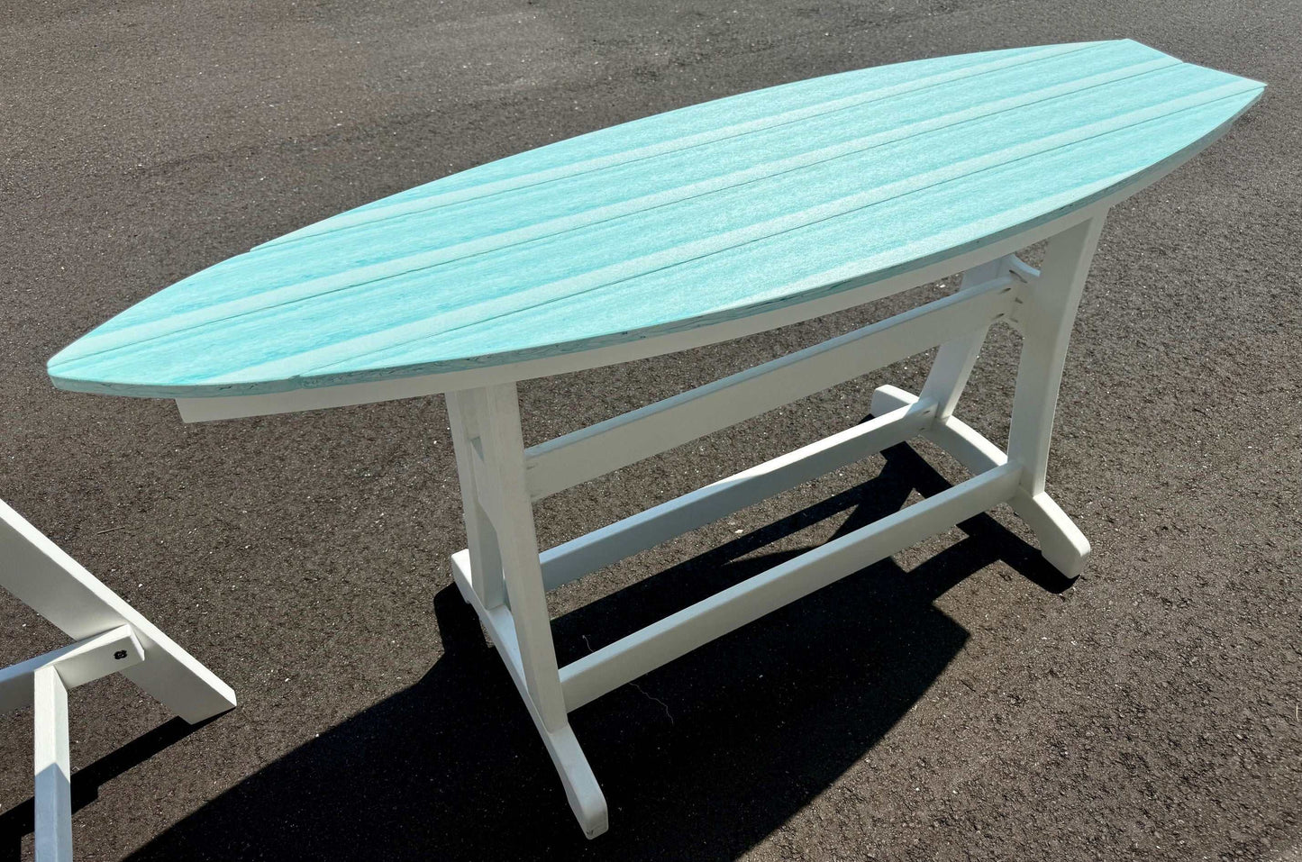 Outdoor surfboard table with turquoise top and white base, weather-resistant patio furniture with coastal design