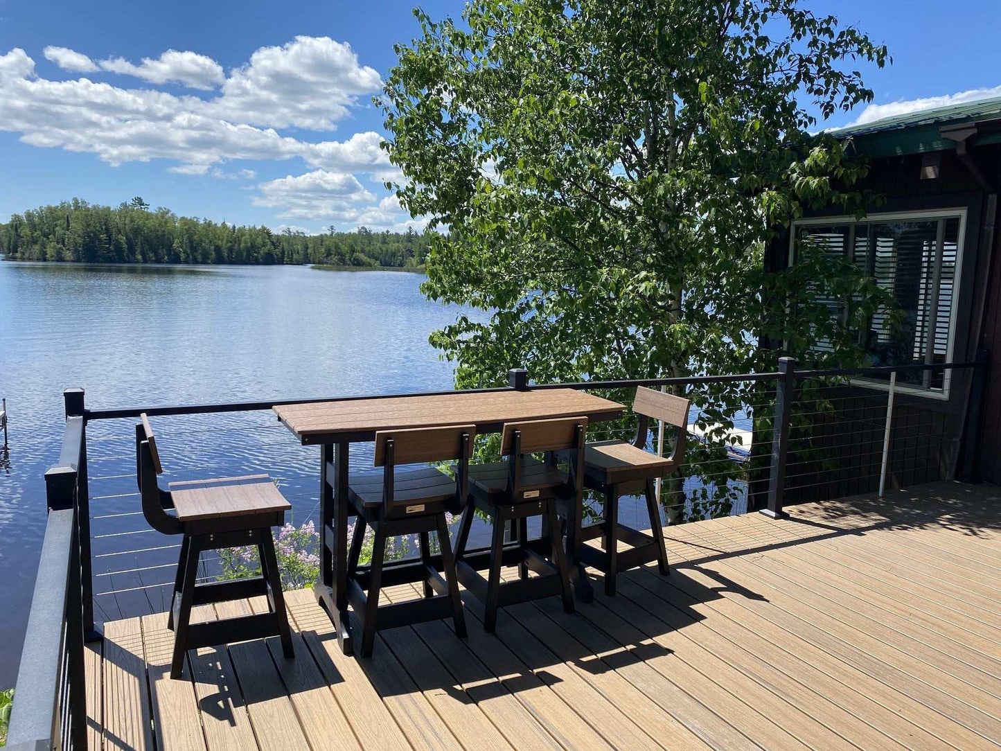 Outdoor Lanai Table set on deck overlooking lake with bar height seating in natural light